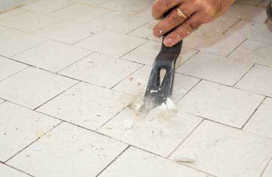 chipping up old tile on a renovation job in erie